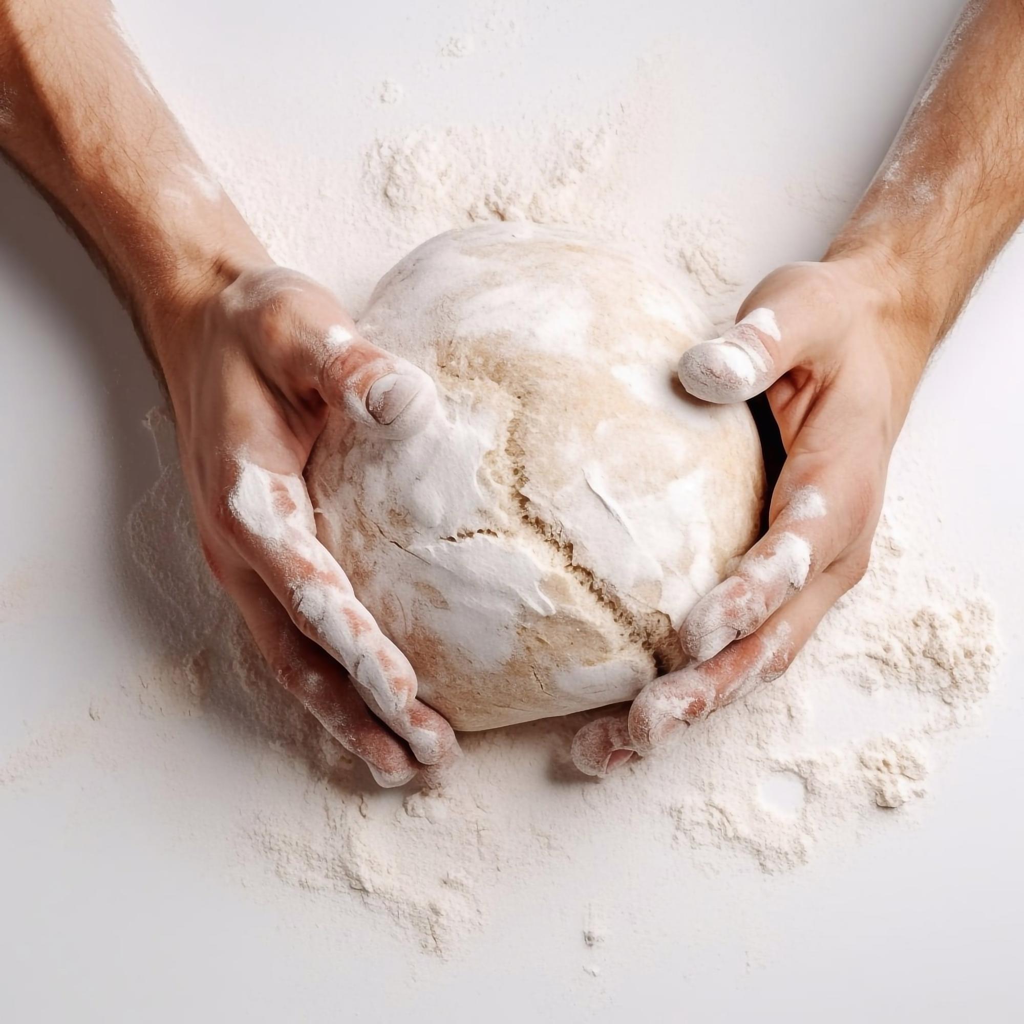 Close-up of artisan hands preparing dough in warm kitchen